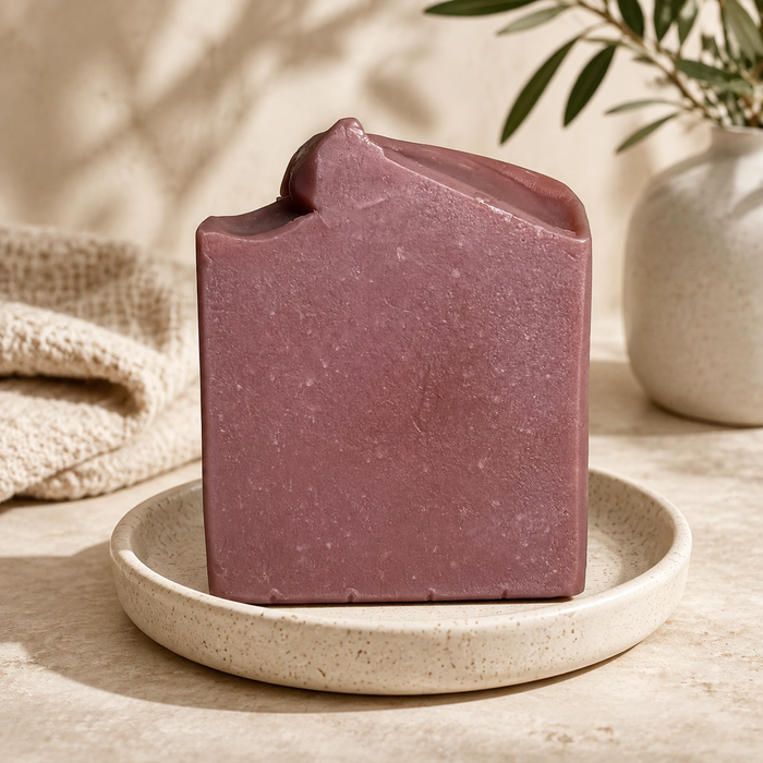 Mauve Opium handmade soap bar on a ceramic dish in a warm neutral setting
